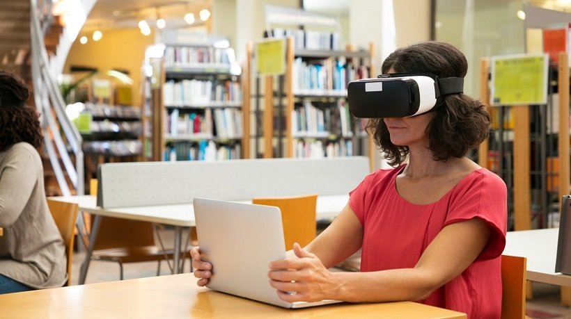 Female trainee using VR simulator in library